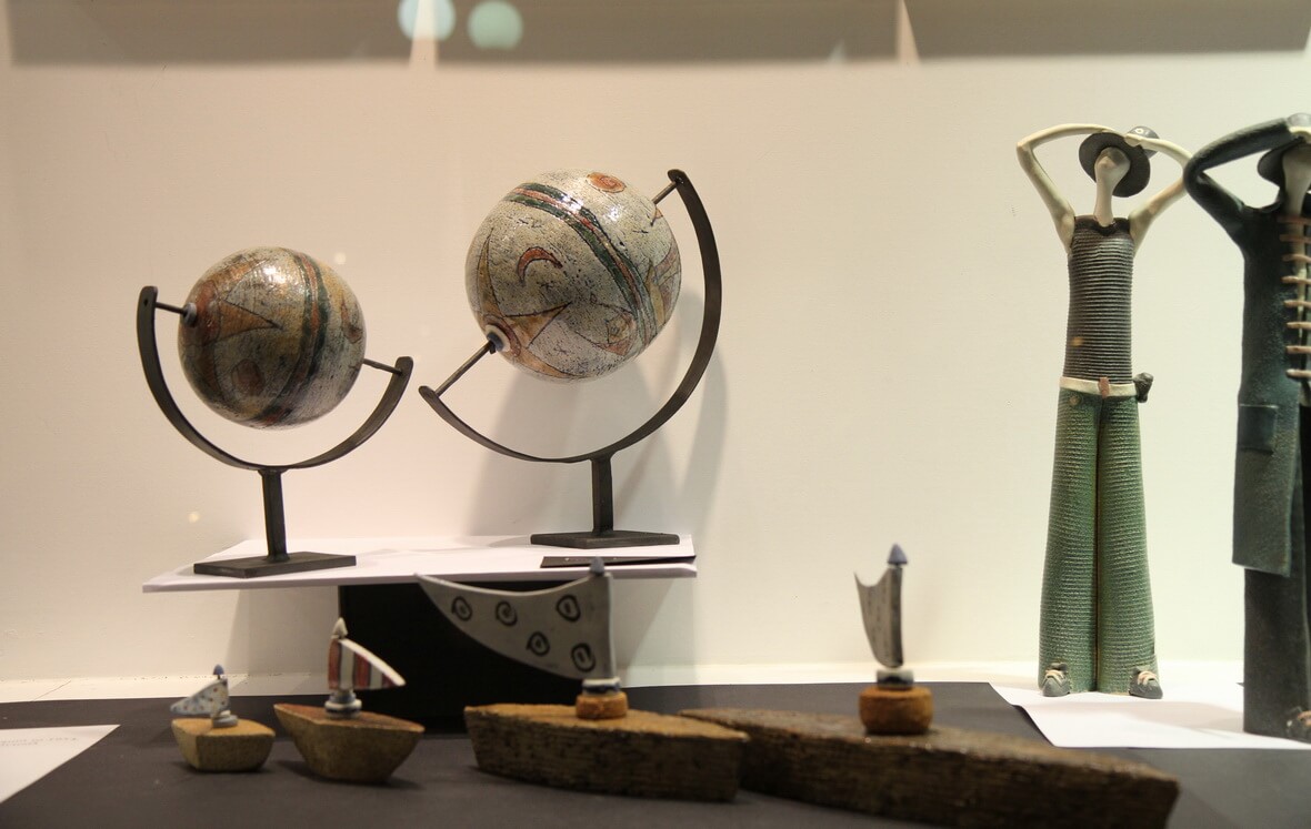 Photograph of earth globes and other exhibits from the Attilio event entitled "A Shop window, a... Journey"