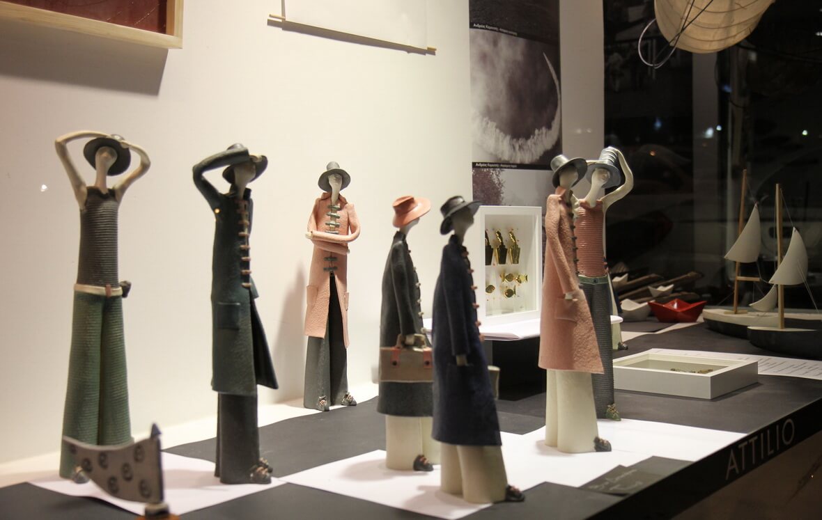 Photo of clay exhibits of human figures with hats from the Attilio event entitled "A shop window, a… Journey"